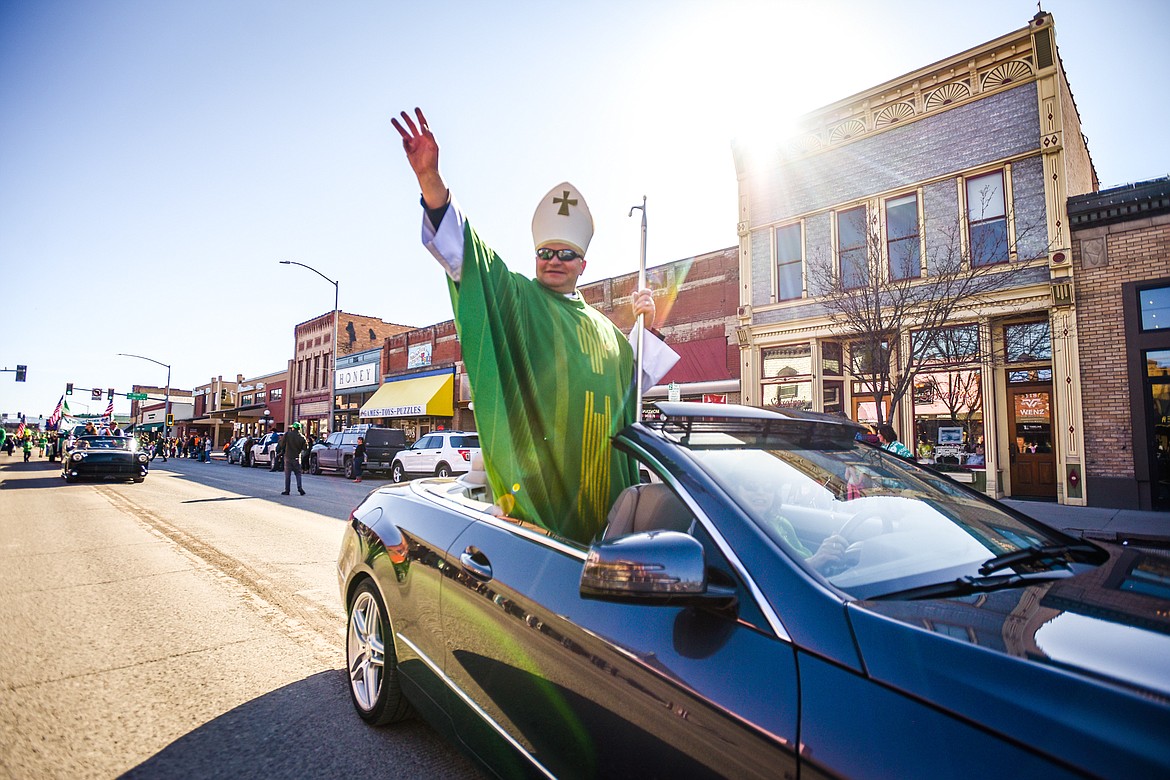 Father Stanislaw Rog, from St. Matthew's Catholic Church, rides in a vehicle during the St. Patrick's Day Parade in Kalispell on Friday, March 17. (Casey Kreider/Daily Inter Lake)