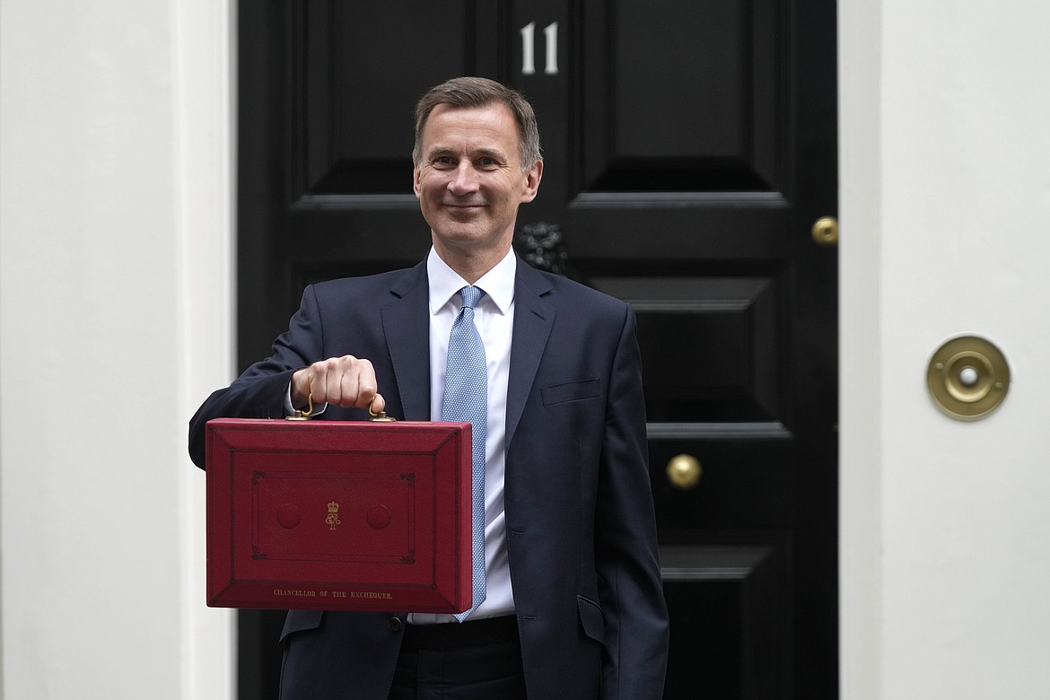 Britain's Chancellor of the Exchequer Jeremy Hunt poses for the media with his traditional Red ministerial box as he leaves 11 Downing Street for the House of Commons to deliver the Budget in London, Wednesday, March 15, 2023. (AP Photo/Frank Augstein)