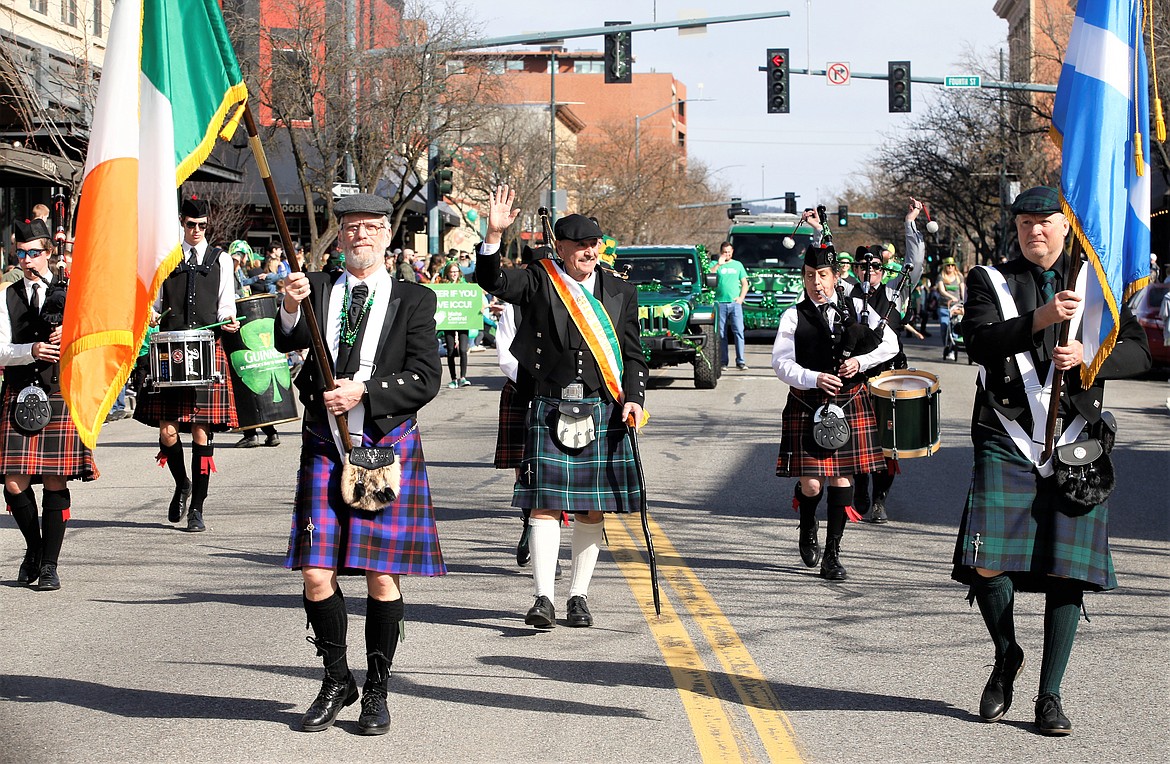 Doug Eastwood, center, grand marshal of the St. Patrick’s Day Parade, waves to the crowd on Saturday. Leading the way and carrying flags are Craig Moss, left, and Doug Kearns.