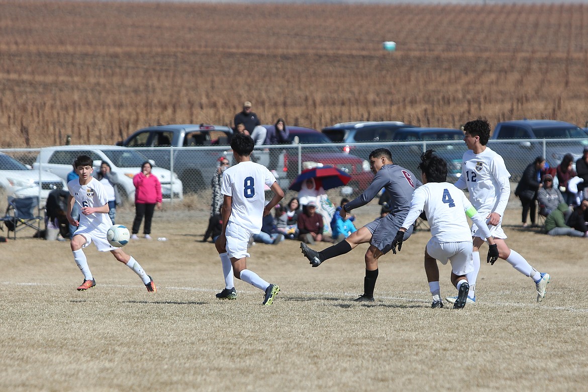 Wahluke senior Juan Bravo, in gray, threads the needle on a shot for a goal in the first half against Wapato.
