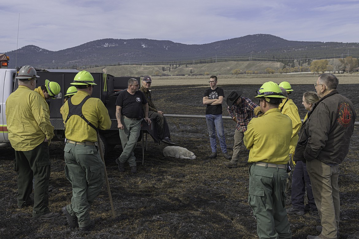 Assistant Chief Brian Reed conducts an incident review after a grass fire was put out Saturday near Plains. (Tracy Scott/Valley Press)