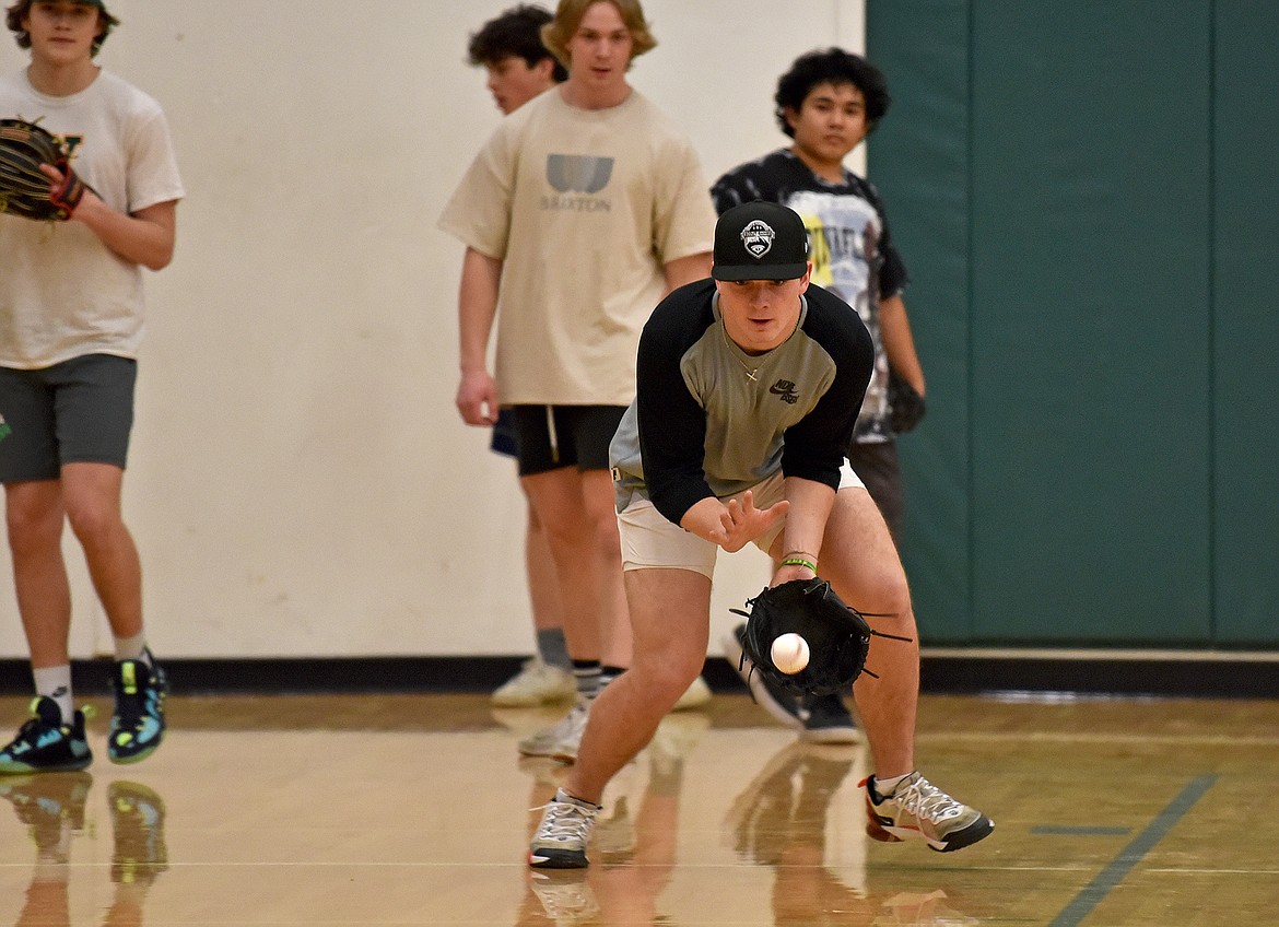 Whitefish senior Ty Schwaiger catches a baseball during practice in the WHS gym on Wednesday, March 15. (Whitney England/Whitefish Pilot)