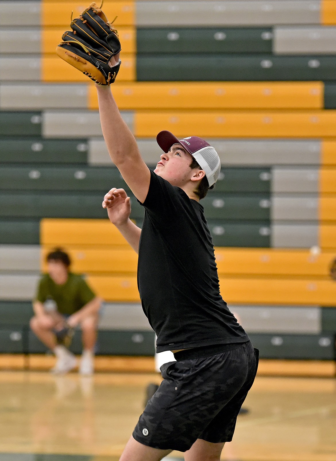 Bulldog JJ McKay reaches to make a catch during baseball practice in the WHS gym on Wednesday, March 15. (Whitney England/Whitefish Pilot)