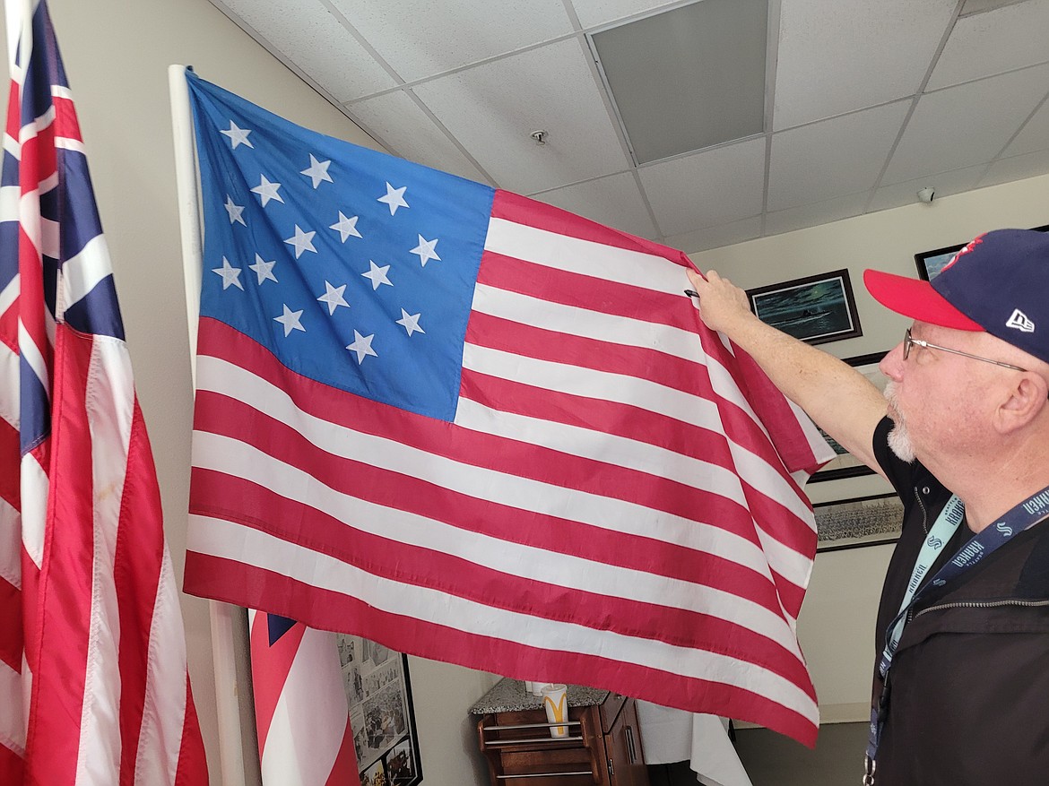 American Legion Post 143 Adjutant Tim Shaw on Tuesday shows the 15-star flag, one of the flags in the Post's American battle flag display. Confederate flags were removed from the display following a patron taking to social media regarding a Confederate flag that was in the collection.