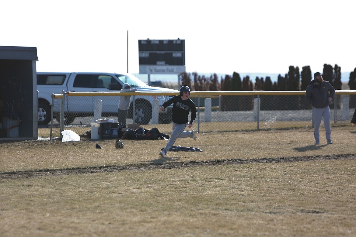 ACH sophomore Carter Pitts, in black, smiles as he rounds third base in an intrasquad scrimmage during practice.