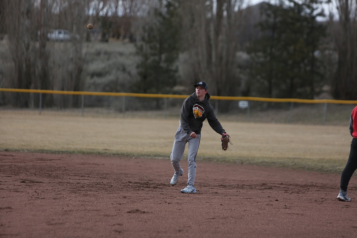 LRS junior Talus O’Brien tosses a ball during fielding drills in a Bronco practice on March 13.