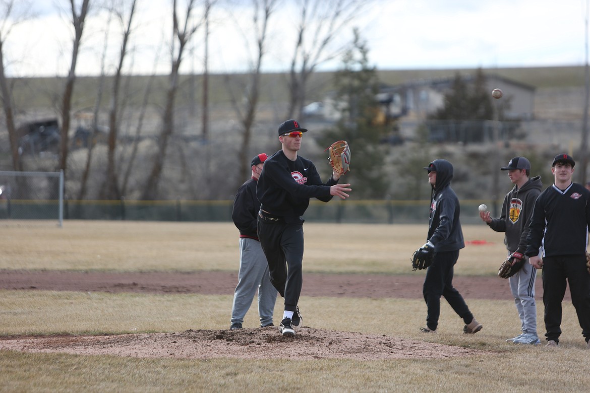 LRS senior Chase Galbreath, in black, throws the ball from the pitcher’s mound to a teammate.