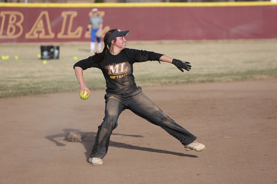 Moses Lake junior Raegen Hofheins throws the ball to first base during a fielding drill in a Maverick practice on March 17.