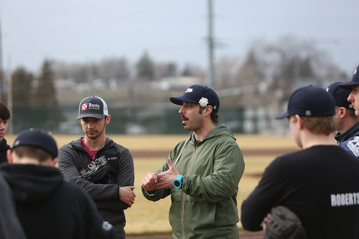 MLCA/CCS Head Coach C.J. Cheatwood, in green, talks about a previous game with players before practice.