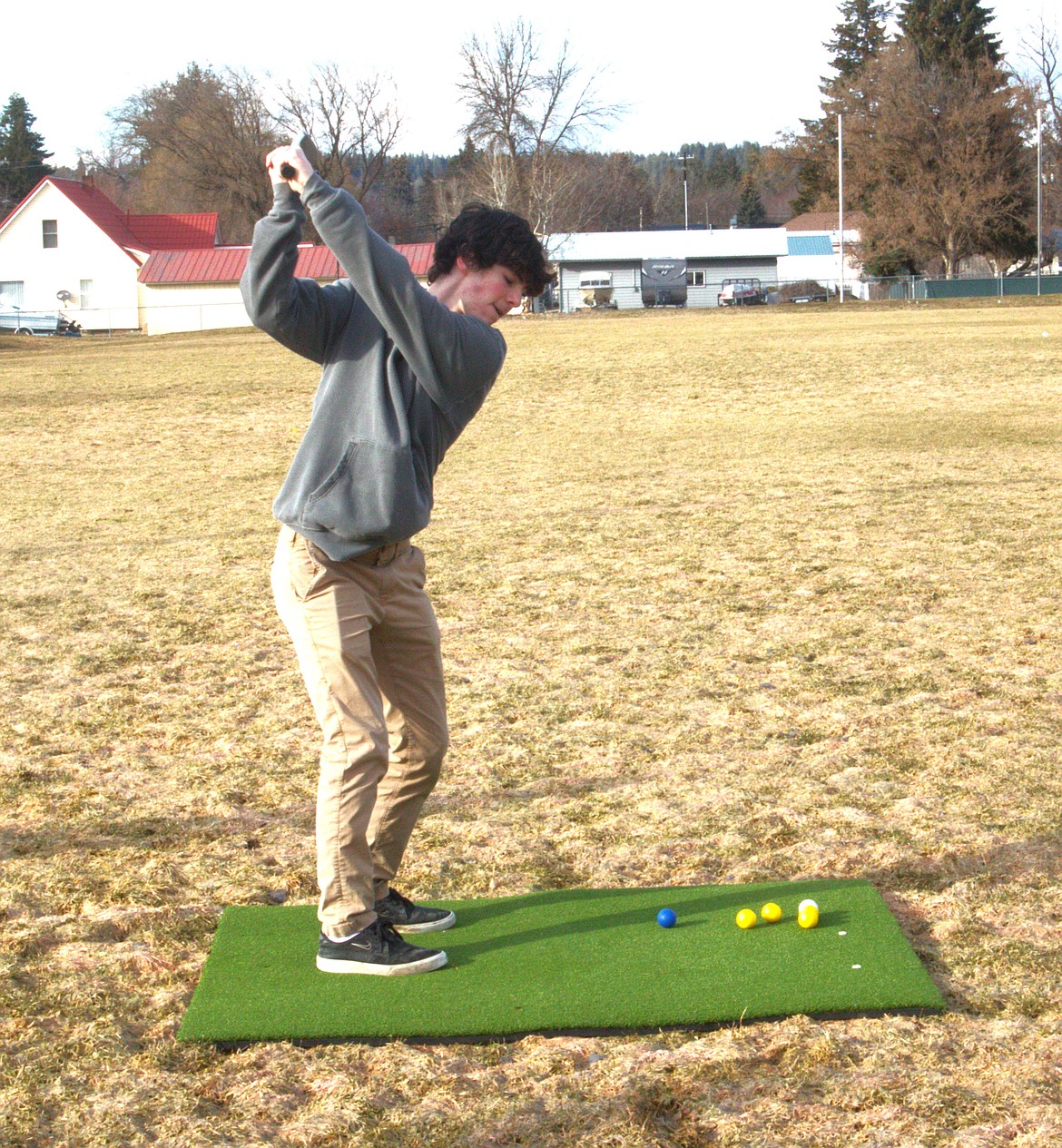 Eli Blackmore practices driving swing at golf practice.