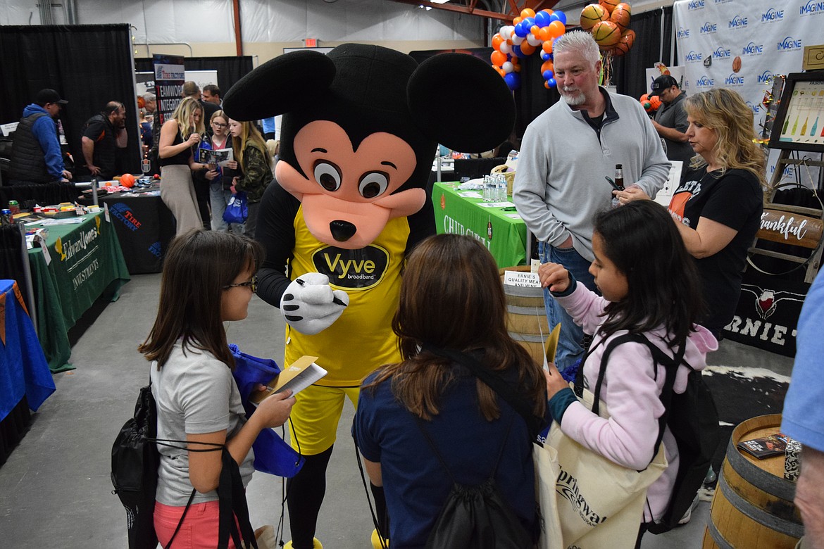 A group of young expo attendees gets their business booth bingo cards stamped by Mickey Mouse of Vyve, a local broadband internet provider, during the annual Moses Lake Chamber of Commerce’s Business Expo at the Grant County Fairgrounds on Tuesday.