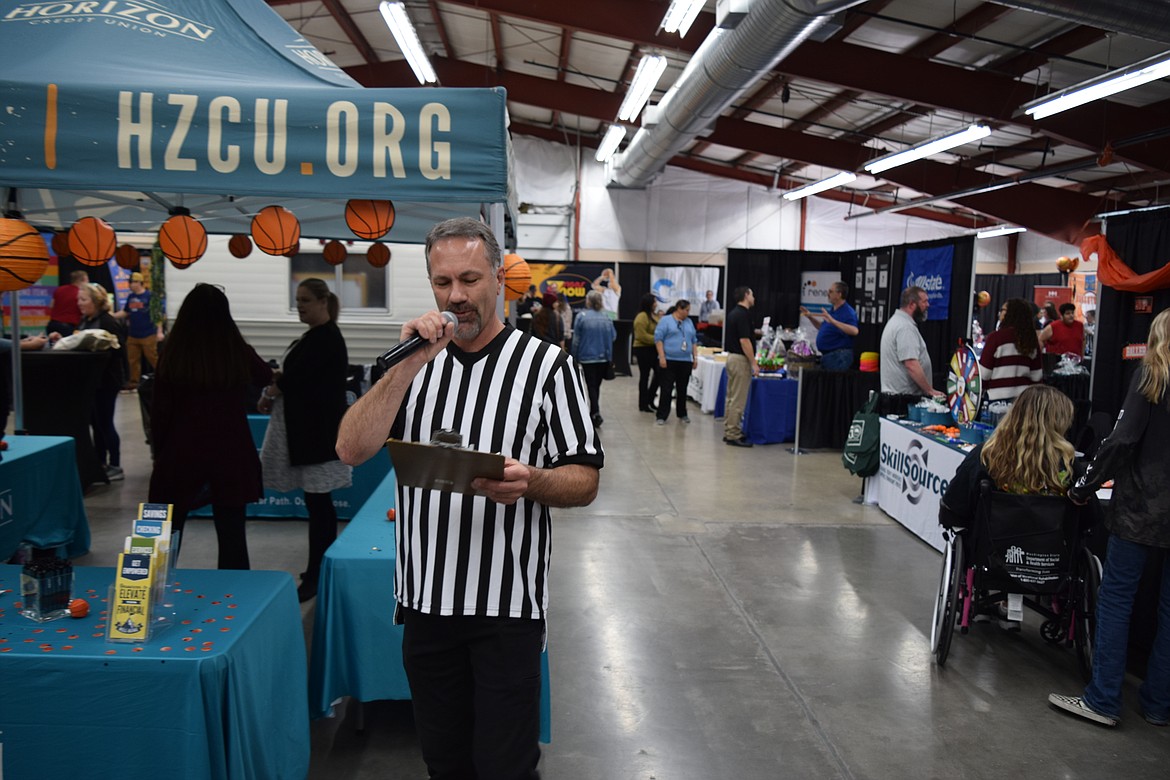 Real estate agent and Moses Lake Chamber of Commerce ambassador Alan Heroux, dressed as a basketball referee, makes an announcement during the chamber’s annual Business Expo on Tuesday.