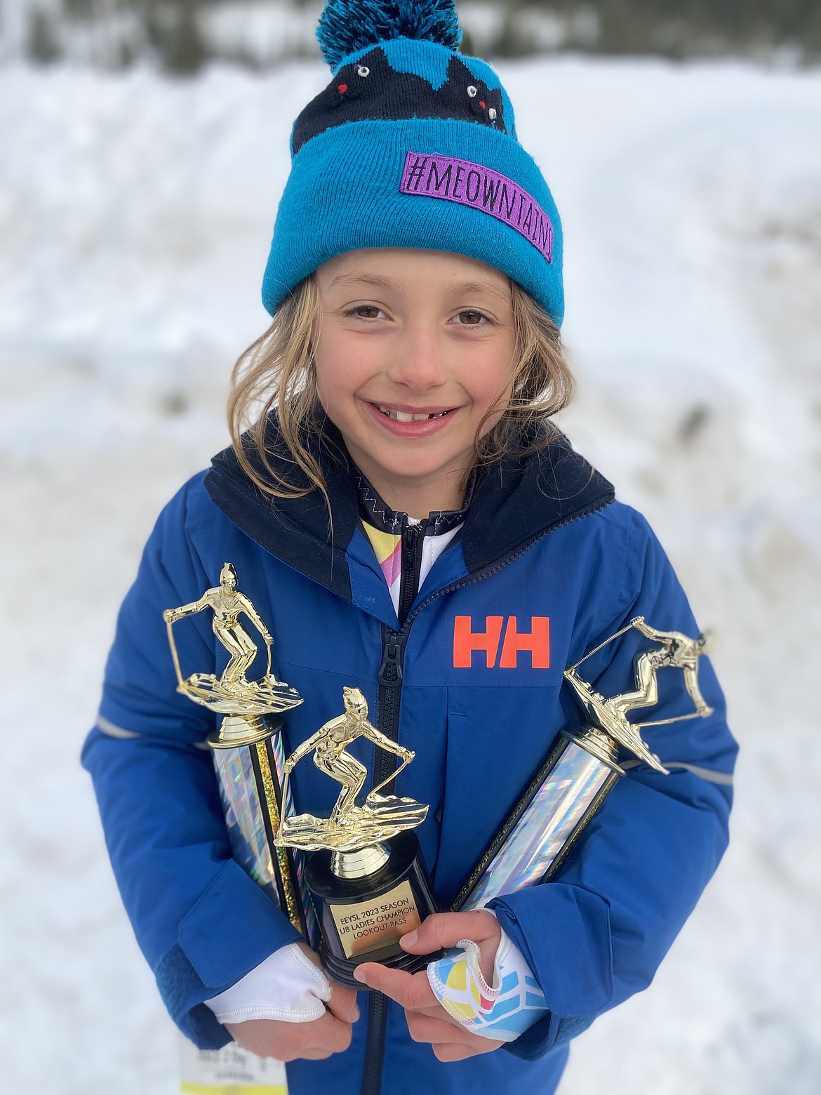 Ever “Sissy” Scherr, 7, holds the trophies that she won at a series of recent races.