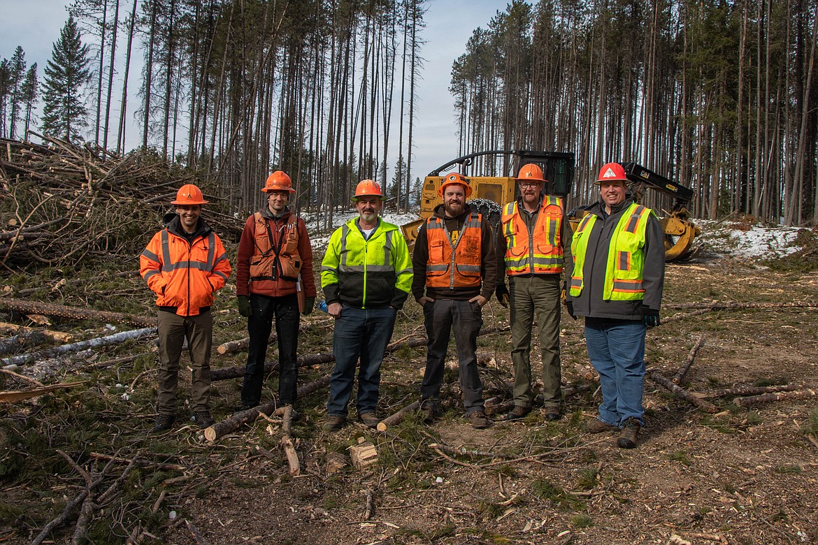 Indepedent contractors, Forest Service workers, Weyerhaeuser employees, and foresters are seen on a logging landing near Coram on March 9, 2023. (Kate Heston/Daily Inter Lake)