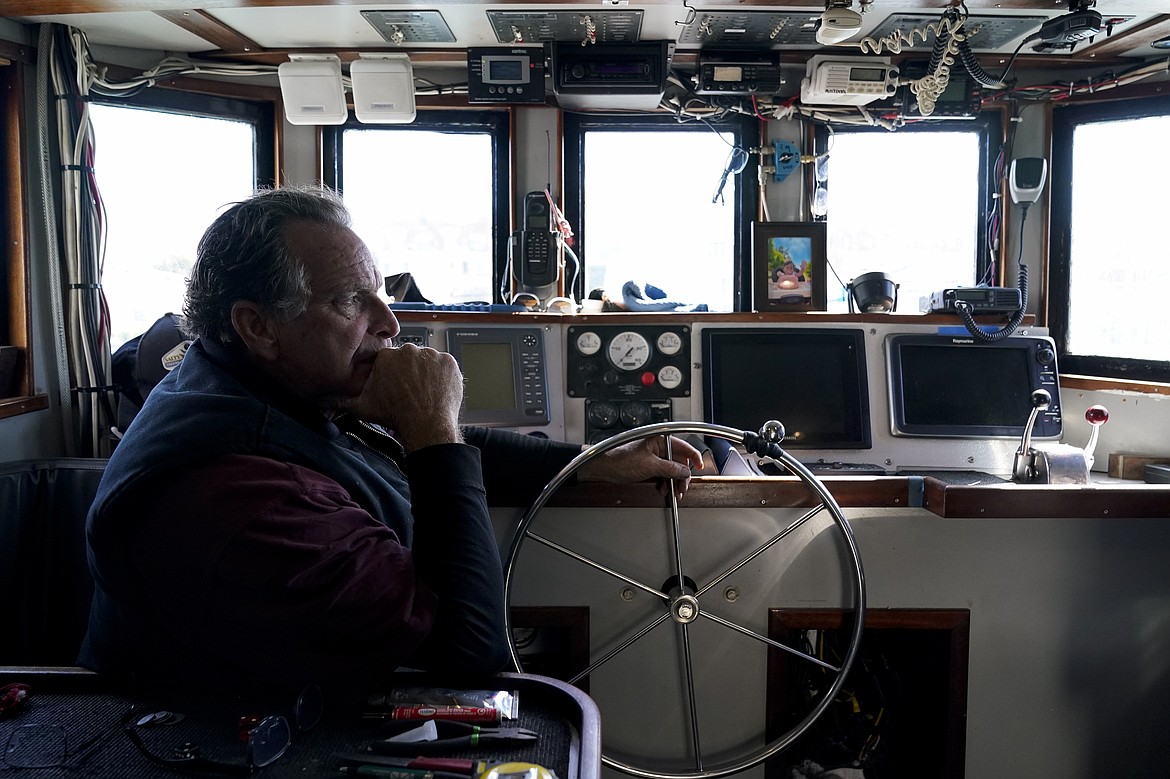 Bob Maharry sits inside his fishing boat docked at Pier 45 in San Francisco, Monday, March 20, 2023. This would usually be a busy time of year for Maharry and his crew as salmon fishing season approaches. On April 7, the Pacific Fishery Management Council, the regulatory group that advises federal officials, will take action on what to do about the 2023 season for both commercial and recreational salmon fishing. (AP Photo/Godofredo A. Vásquez)