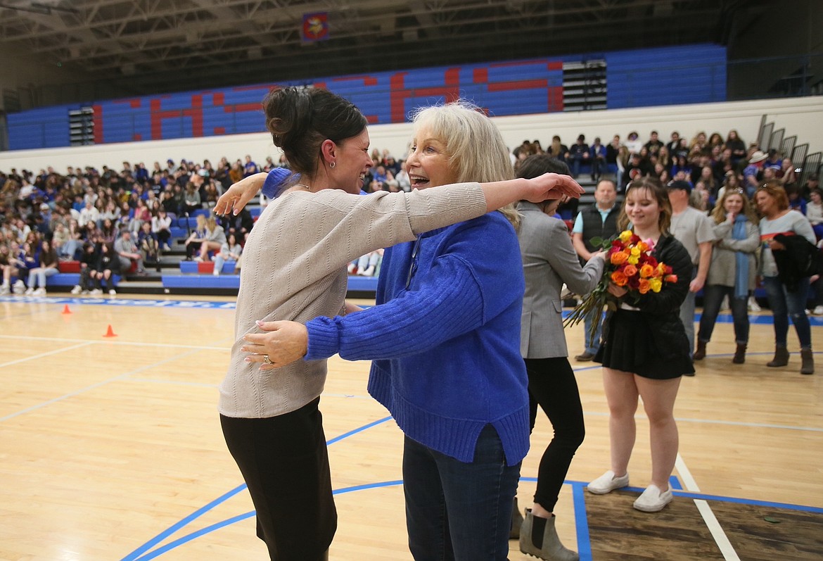 Former student Karen Santos gives a happily surprised Eileen Bieber a huge hug Friday as Bieber is honored for her contributions to Coeur d'Alene High School for the past 50 years. "I love her," Santos said. "She is my most favorite teacher ever in the world."