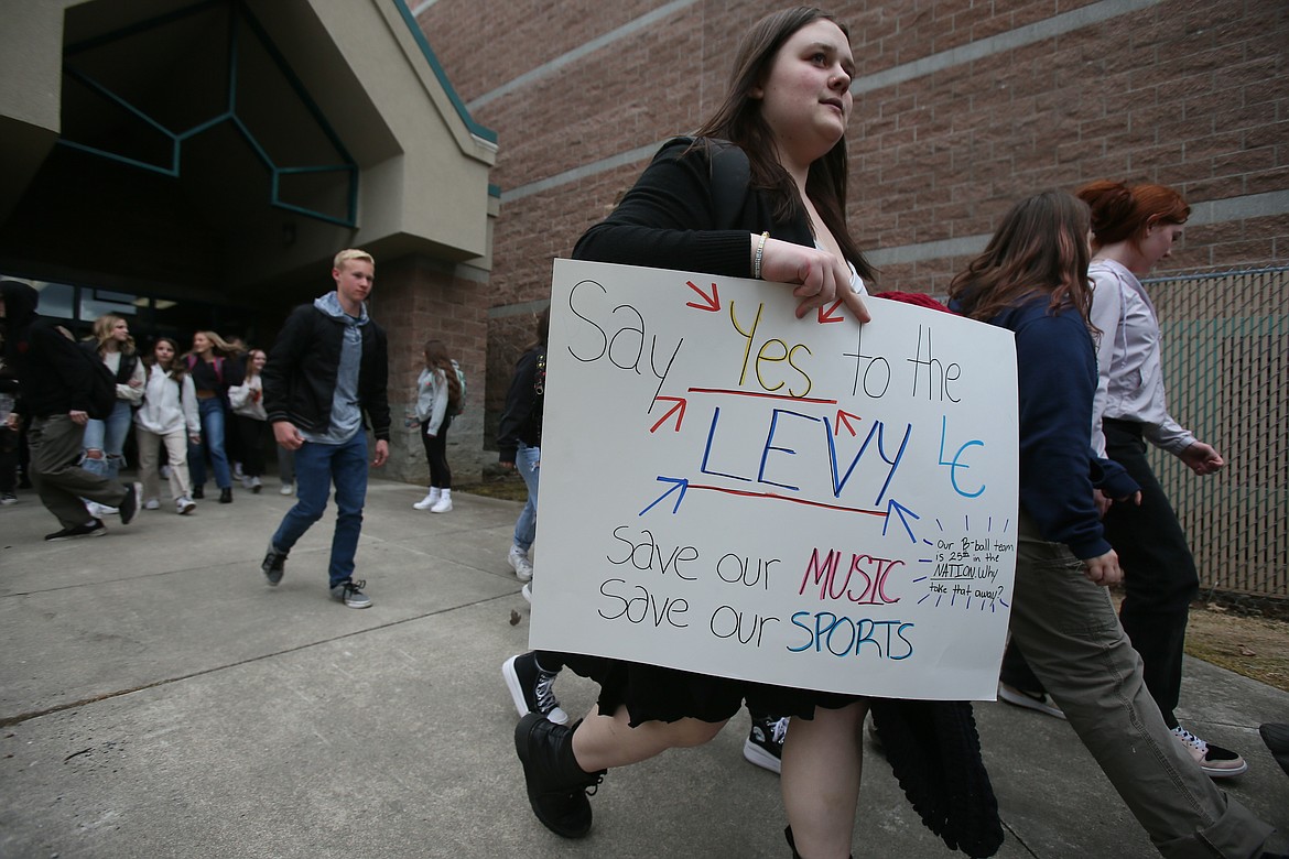 Students carry signs and rally Friday in response to the March 14 failure of the supplemental levy.