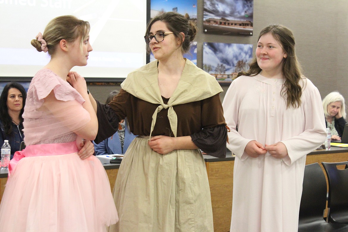 Marmee (Ella Beck), center, gives Meg (Evan Arledge), right, some advice on going to a ball while Beth (Calissa Dalton) listens with interest. The cast of the Moses Lake High School production of “Little Women” performed a song from the show at the Moses Lake School Board meeting Thursday.