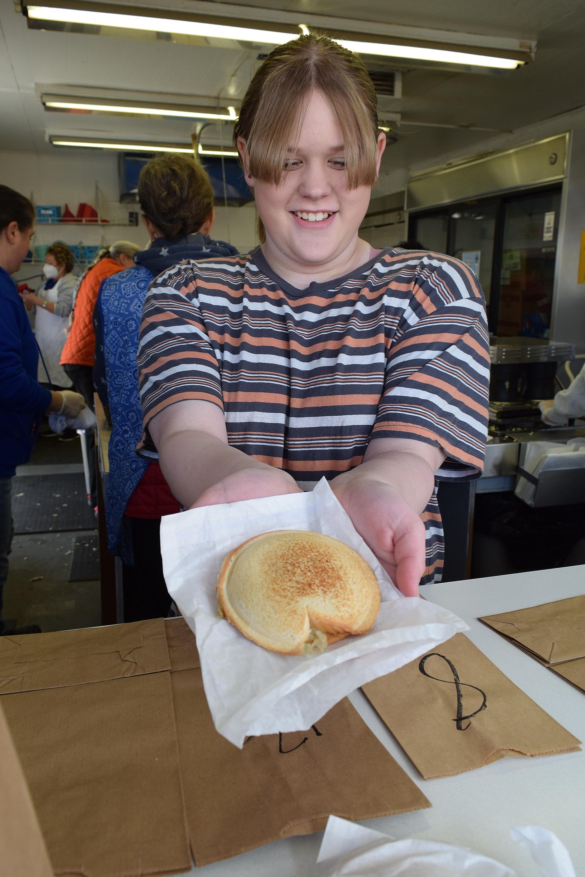 Sam Haring, 12, holds up a Spaceburger prepared by the Lioness Club of Moses Lake and sold out of the club’s booth at the Grant County Fairgrounds. The club opened up its booth to make and sell Spaceburgers on Friday, Saturday and Sunday to raise money for local charities and non-profits, with long wait times on Saturday as people lined up. “It’ll be a bit,” said Haring, who volunteered to run the cash register and fill orders. “We’ve gotten nothing but big orders.”