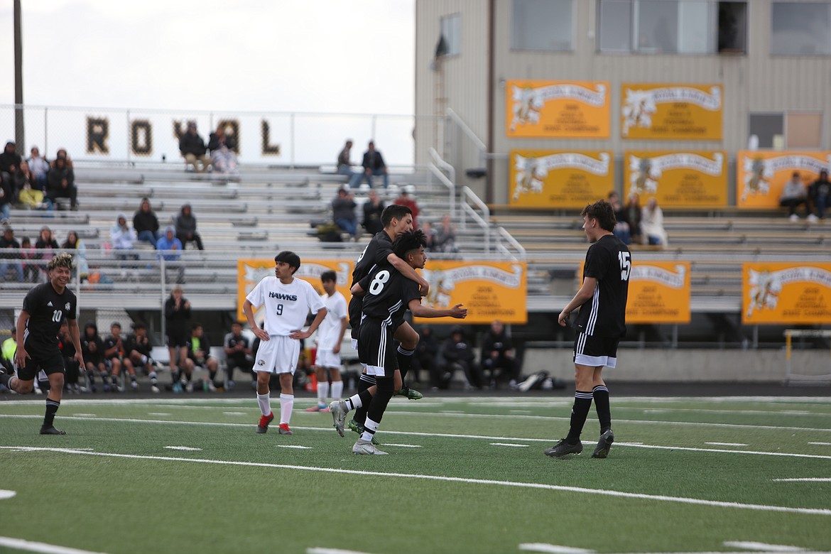 Royal players celebrate after a goal by sophomore Victor Aquino.