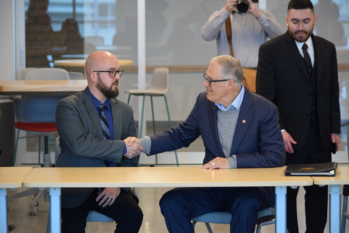 Governor Jay Inslee, right, shakes hands with Moses Lake Mayor Don Myers during a visit to the area Tuesday where Inslee sought to offer support for local tech companies.