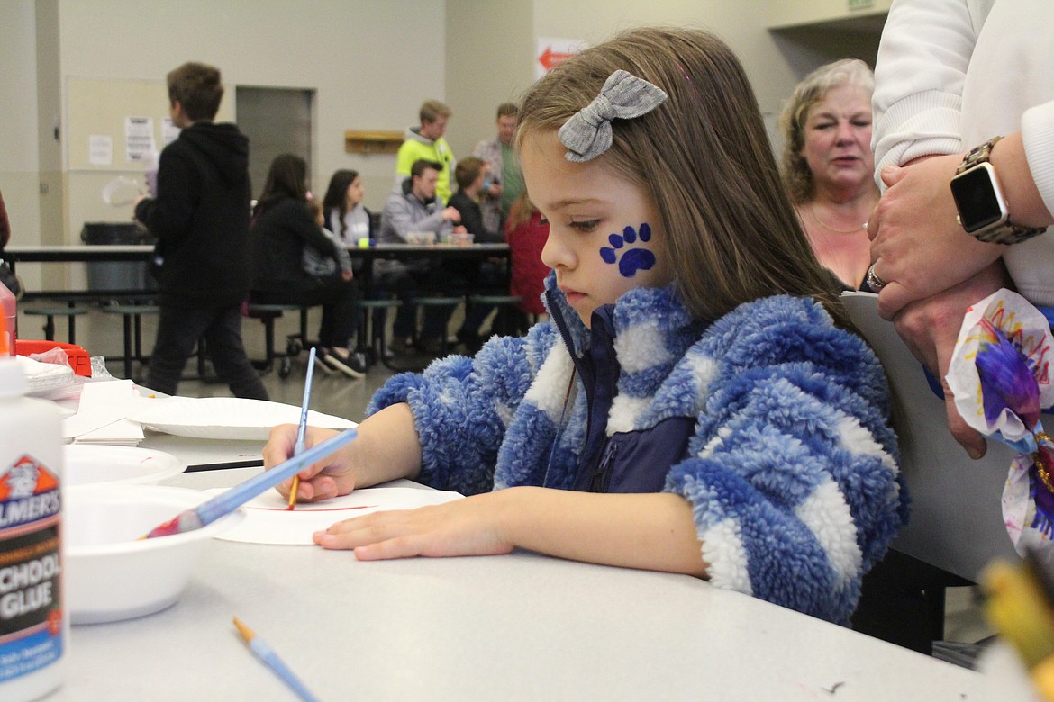 Teagan McCuistian paints a bird mask at Saturday’s Sandhill Crane Festival in Othello.