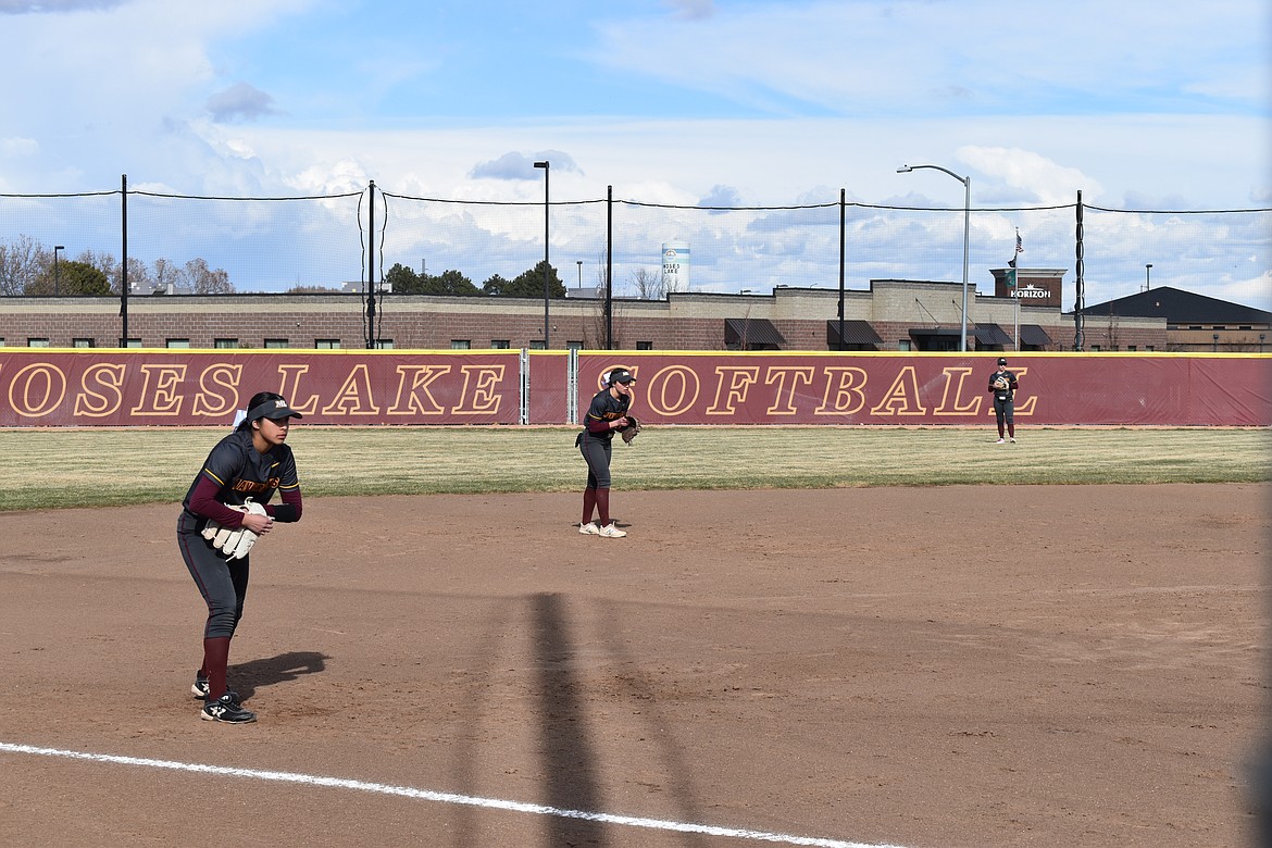 Moses Lake senior Jazlynn Torres, left, stands at third base, and junior Raegen Hofheins, center, plays in her shortstop position while senior Ali Stanley, right, stands in the outfield.