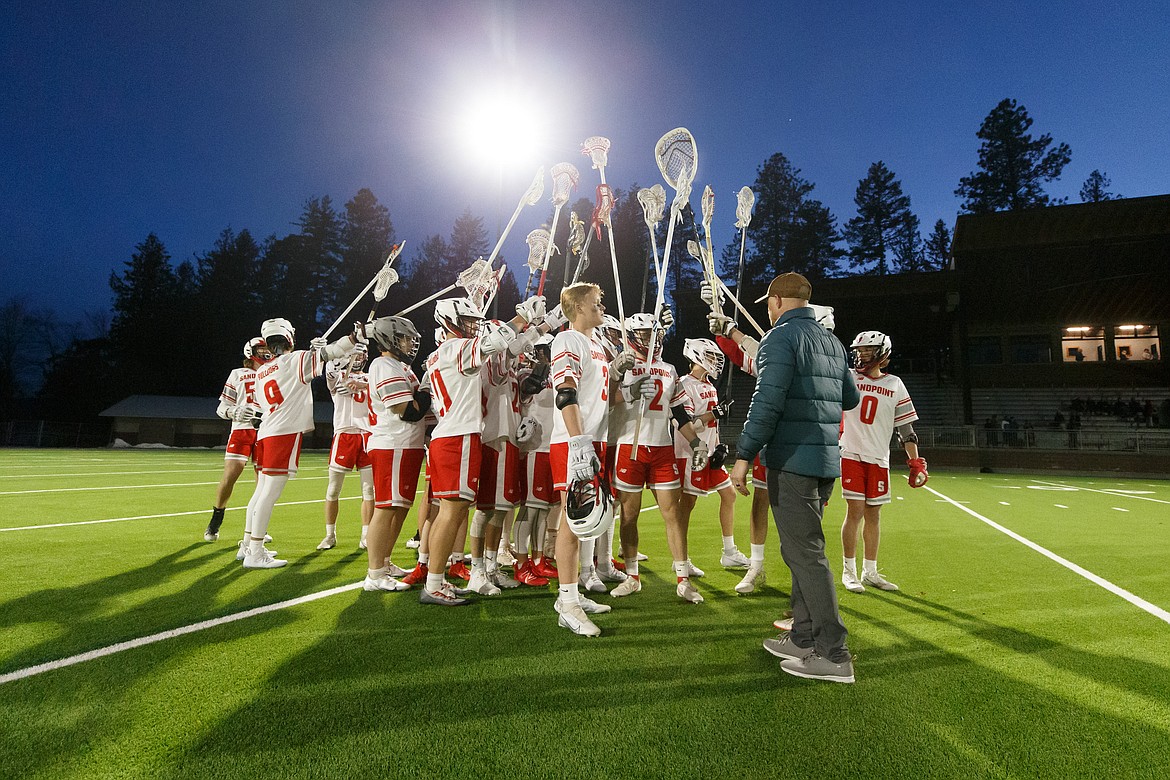 Sandpoint boys lacrosse raise their sticks in the air defeating Logos for their first win of the season.