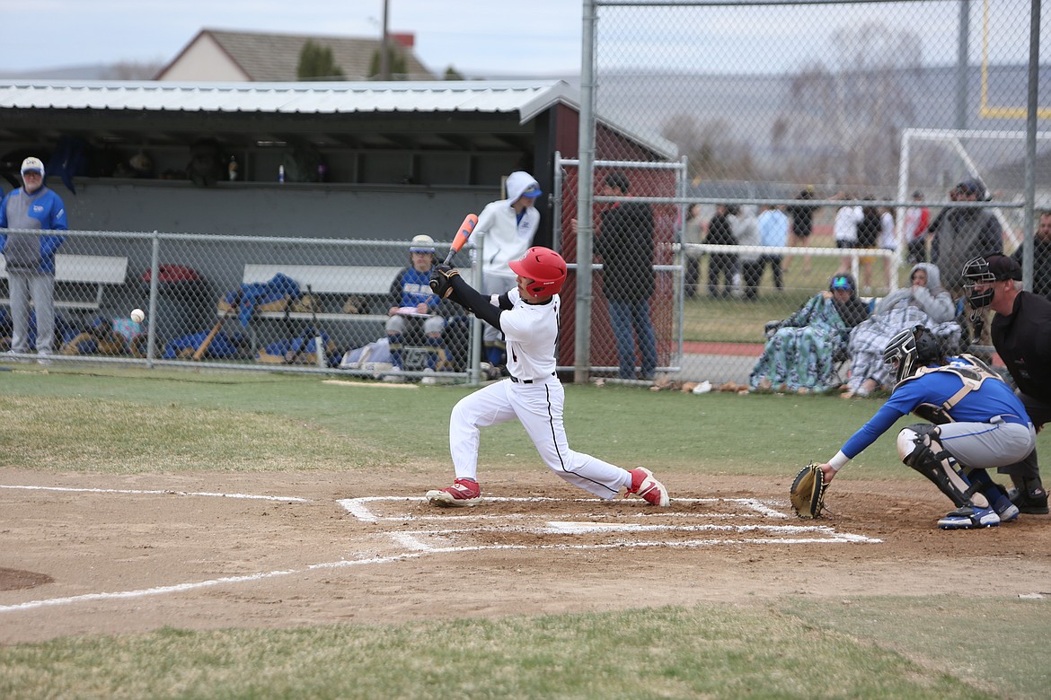 Othello sophomore Kal-El Ozuna makes contact with a Deer Park pitch during the first inning against the Stags.