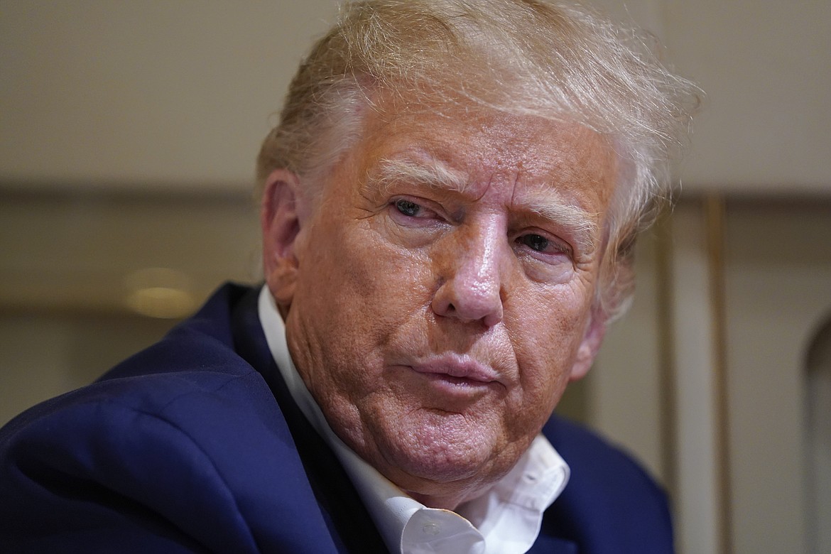 Former President Donald Trump listens as he speaks with reporters while in flight on his plane after a campaign rally at Waco Regional Airport, in Waco, Texas, Saturday, March 25, 2023, while en route to West Palm Beach, Fla. (AP Photo/Evan Vucci)