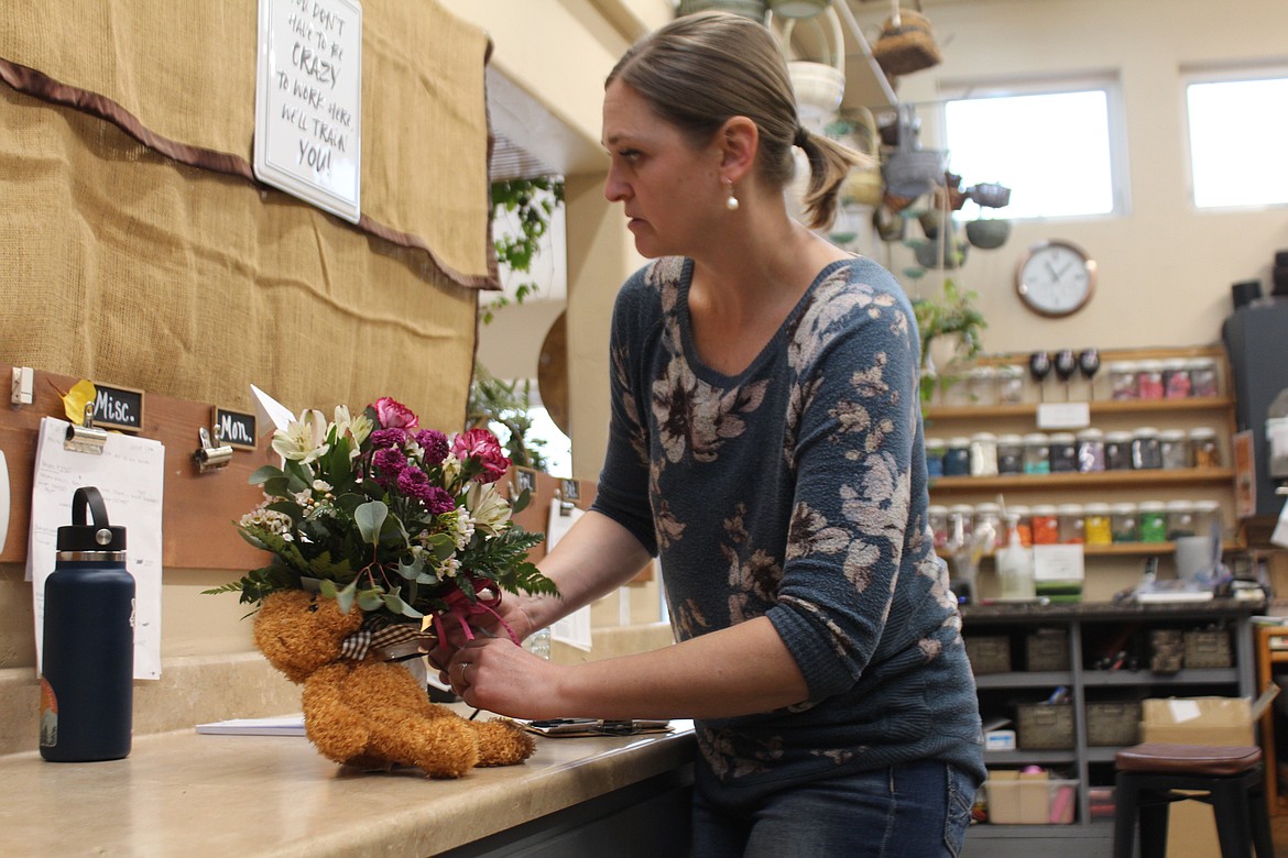 Kristin Mead, co-owner of the Flower Basket, puts the finishing touches on a bouquet.