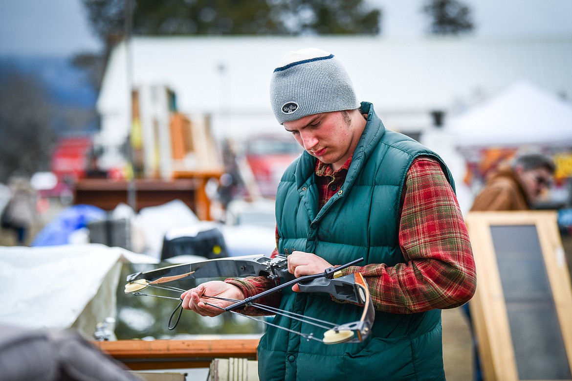Simeon Burton looks over a compound bow at the 57th annual Creston Auction on Saturday, April 1. The Creston Auction and Country Fair is the largest annual fundraiser for the all-volunteer Creston Fire Department and has been held in Creston since 1966. (Casey Kreider/Daily Inter Lake)