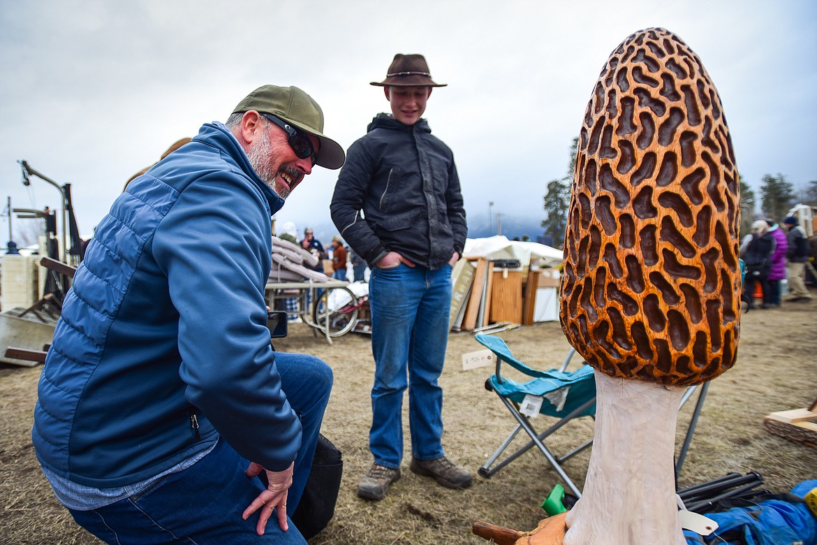 Shoppers check out a morel mushroom woodcarving up for auction at the 57th annual Creston Auction on Saturday, April 1. The Creston Auction and Country Fair is the largest annual fundraiser for the all-volunteer Creston Fire Department and has been held in Creston since 1966. (Casey Kreider/Daily Inter Lake)