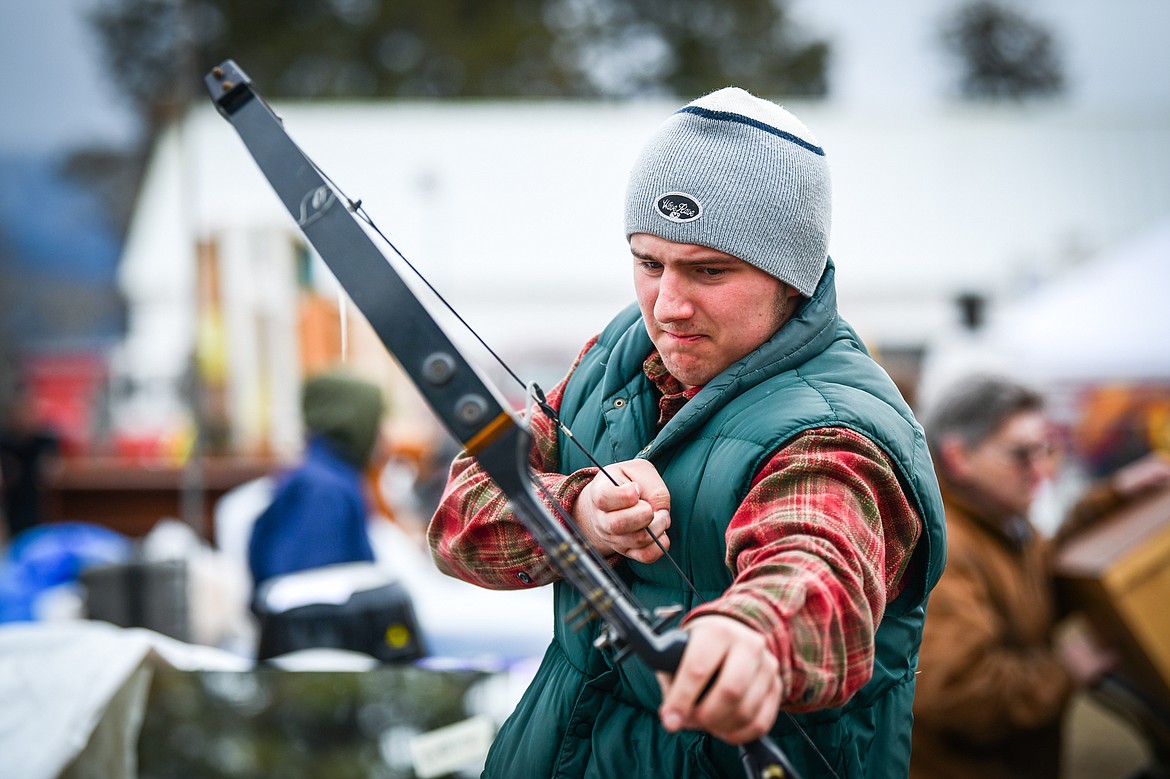 Simeon Burton tests the draw on a compound bow at the 57th annual Creston Auction on Saturday, April 1. The Creston Auction and Country Fair is the largest annual fundraiser for the all-volunteer Creston Fire Department and has been held in Creston since 1966. (Casey Kreider/Daily Inter Lake)
