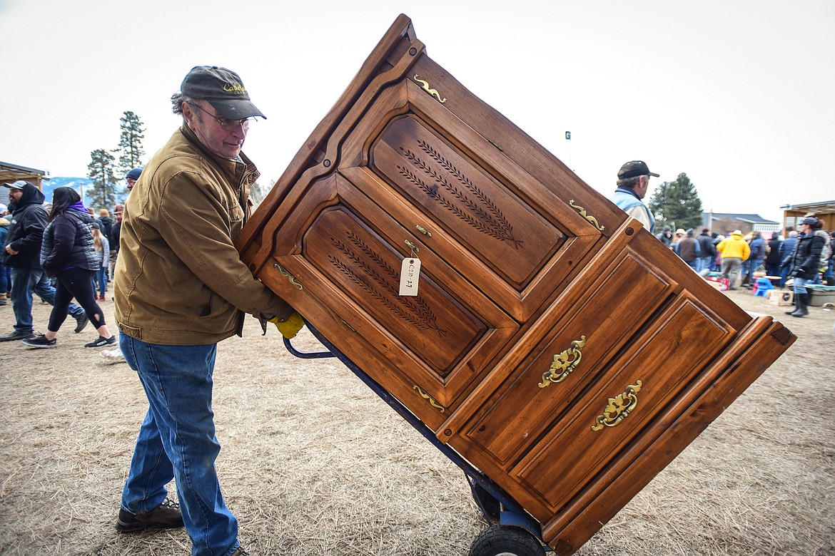 Bob Adkison wheels off a wardrobe he won at the 57th annual Creston Auction on Saturday, April 1. The Creston Auction and Country Fair is the largest annual fundraiser for the all-volunteer Creston Fire Department and has been held in Creston since 1966. (Casey Kreider/Daily Inter Lake)