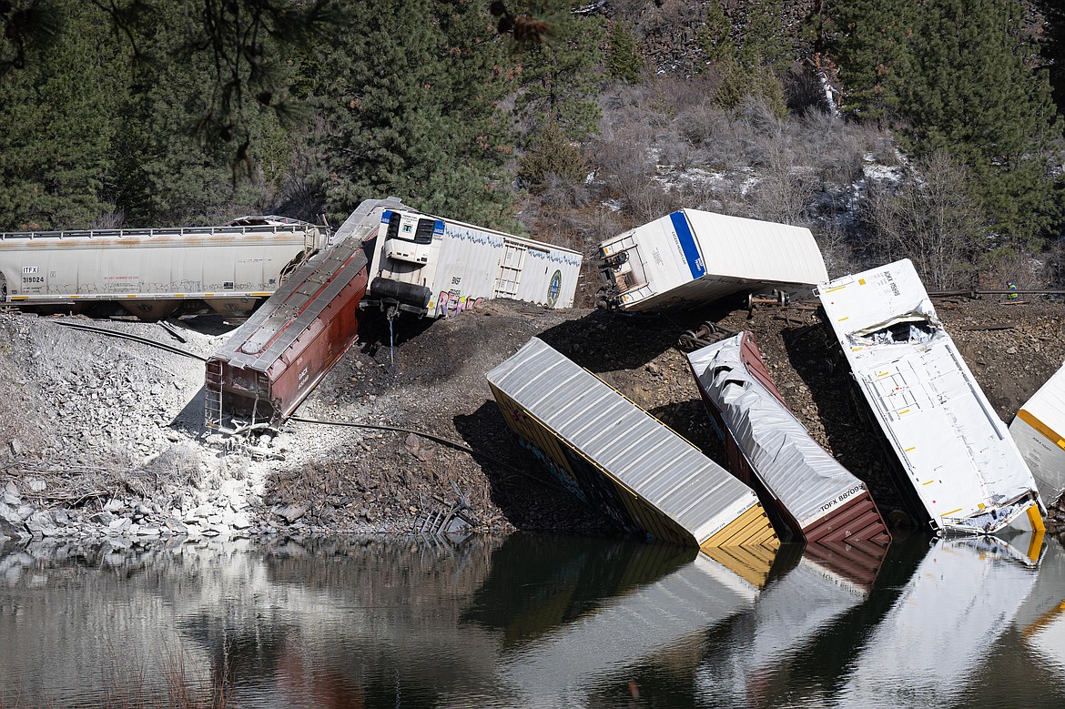 Montana Rail Link freight cars hang along the Clark Fork River following a derailment in Sanders County, Montana on Sunday, April 2, 2023. (Tracy Scott/Clark Fork Valley Press)
