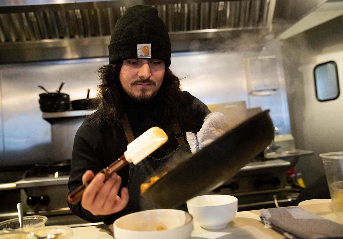 Santos Enrique Camara, 27, who dropped out of Shoreline Community College at age 19 in 2015, prepares food at Capers + Olives Friday, March 24, 2023, in Everett, Wash. where he works as a sous-chef and cook. Advocates for community colleges defend them as the underdogs of America’s higher education system, left to serve the students who need the most support but without the money to provide it. Critics contend this has become an excuse for poor success rates and for the kind of faceless bureaucracies that ultimately led Camara to drop out after two semesters. (AP Photo/Lindsey Wasson)