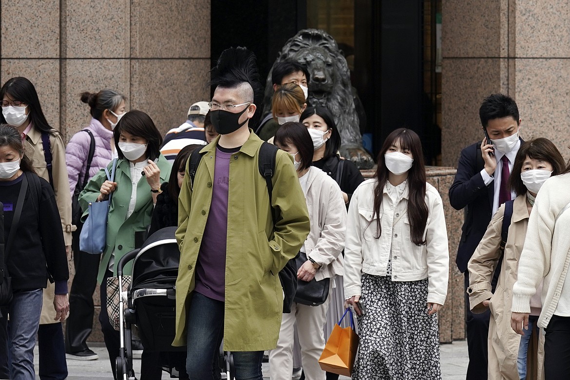 People walk at a pedestrian crossing in Ginza shopping district Friday, March 31, 2023, in Tokyo. Business sentiment among big Japanese manufacturers worsened in the first quarter of this year, marking the fifth straight decline, according to a closely watched central bank survey of business sentiments called "tankan." (AP Photo/Eugene Hoshiko)