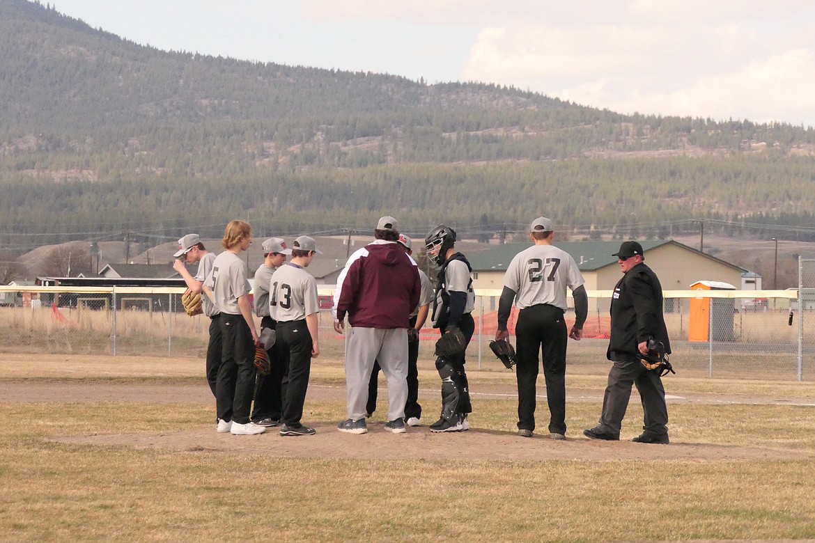 Coach Richard Powers holds a strategy meeting on the pitching mound during the season opening game against Frenchtown at the Amundson Sports  Complex near the Plains airport.  It was the first high school baseball game for Plains and their co-op partner Hot Springs. (Chuck Bandel/VP-MI)