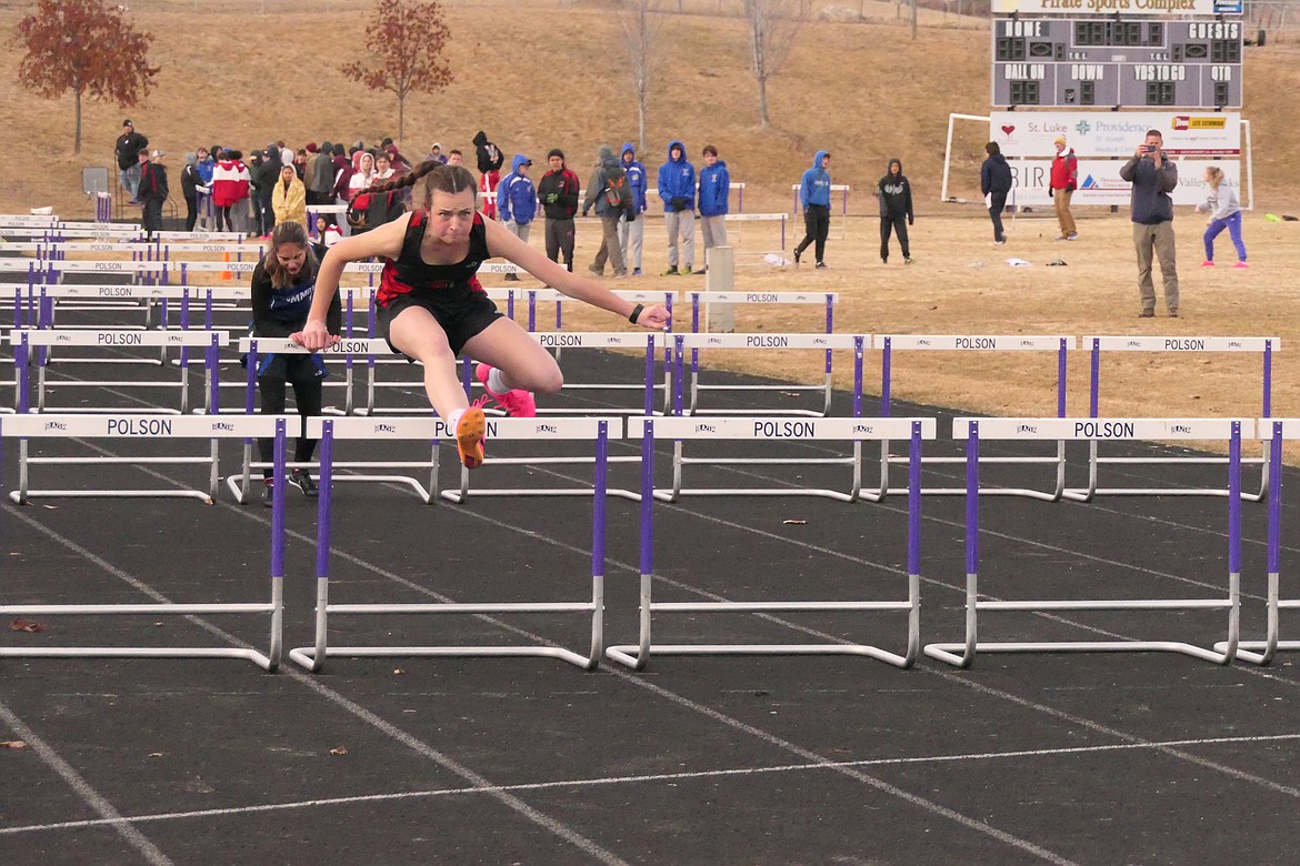 Hot Springs freshman Kara Christensen clears a hurdle in the 100 meters event this past Friday at the Dave Tripp Memorial meet in Polson.  Christensen finished third.  (Chuck Bandel/VP-MI)