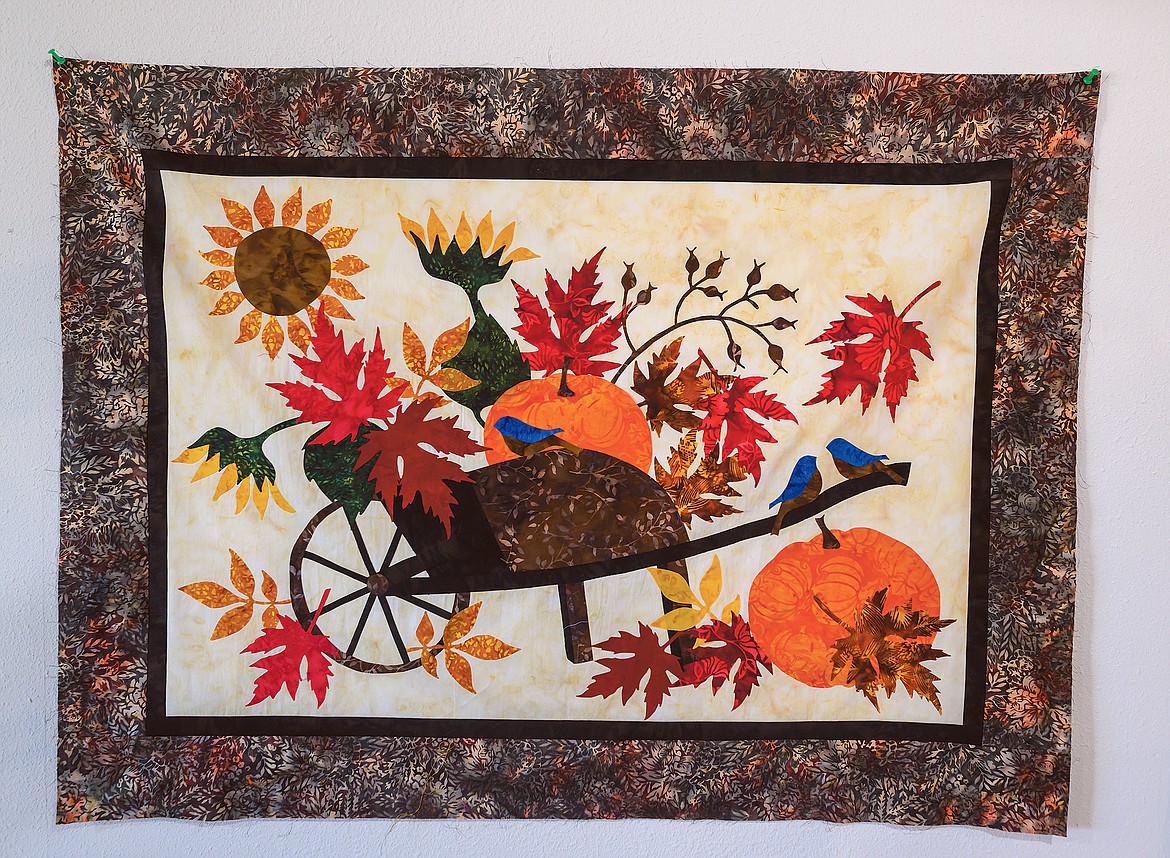 A fall scene with bluebirds are featured on this quilt.
