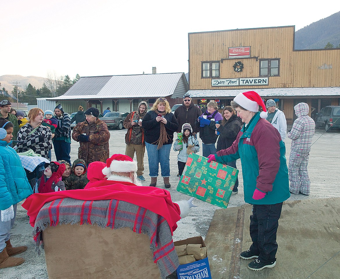Longtime bartender and manager Laura Djonne, right, hands presents to Santa in this file photo. Djonne died in 2017.