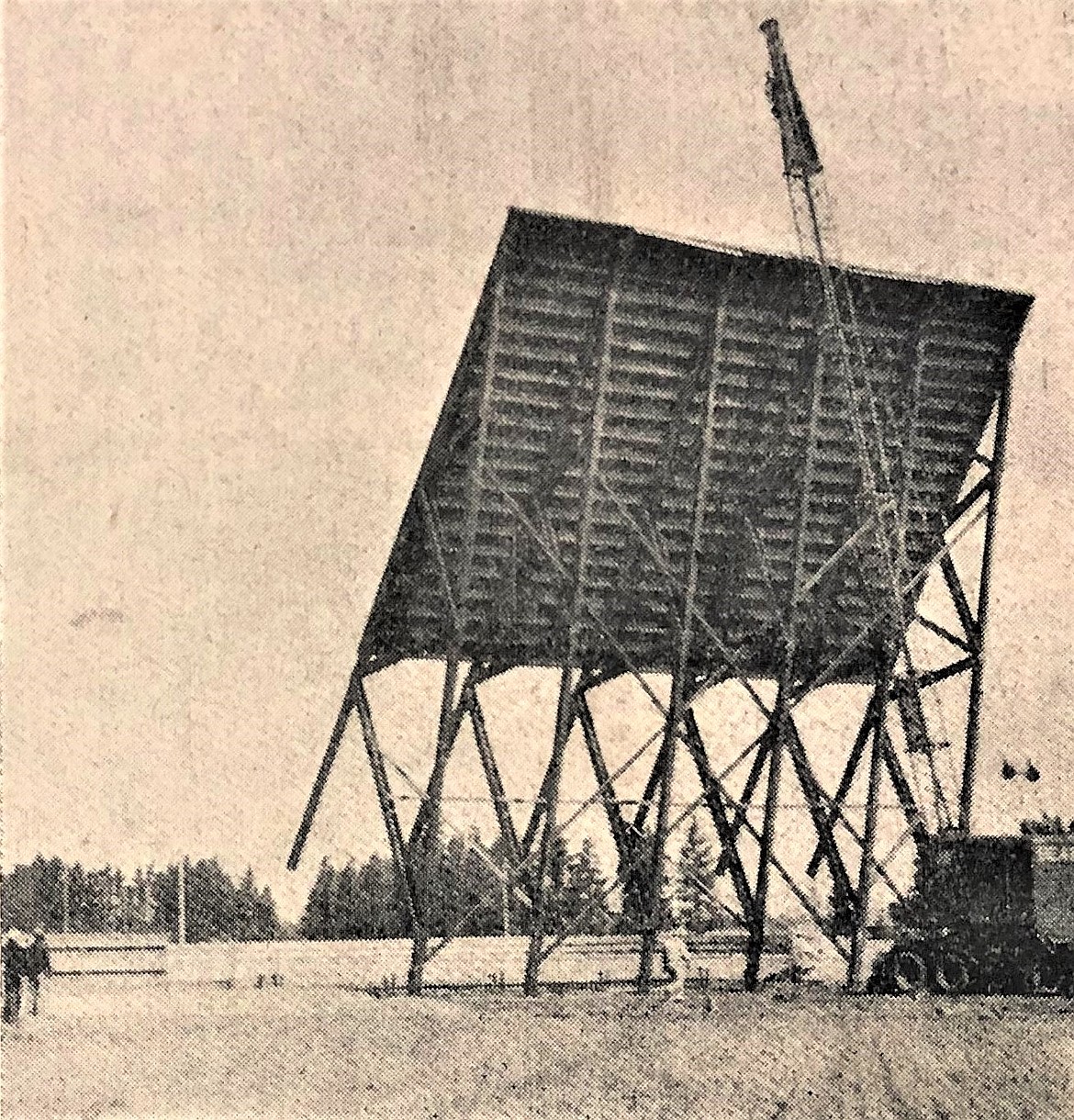 Harley Hudson and a friend (lower left) watch as a crane lifts the 20-ton, Coeur d’Alene Drive-in screen into place.