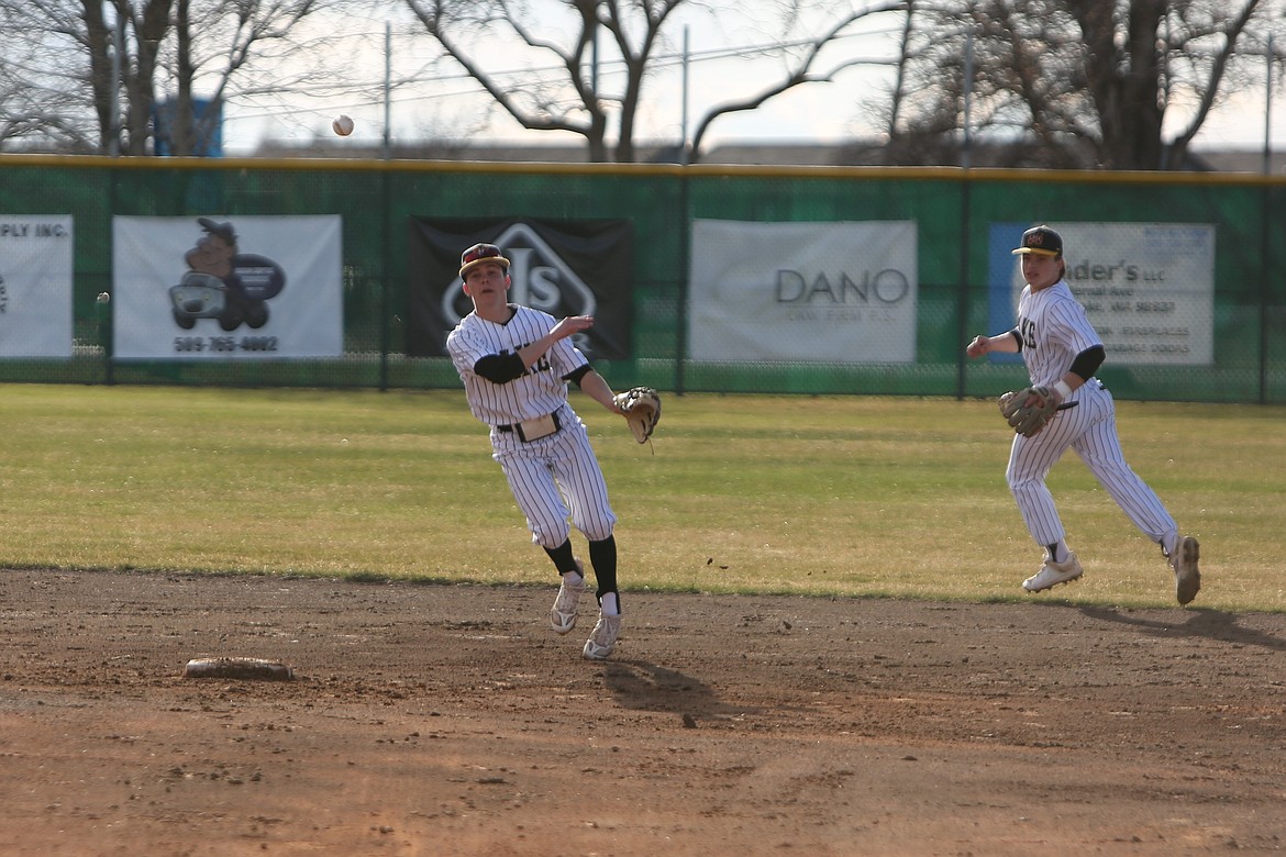 Moses Lake junior Jayce Stuart, left, throws the ball toward first base against Eastmont on Tuesday.