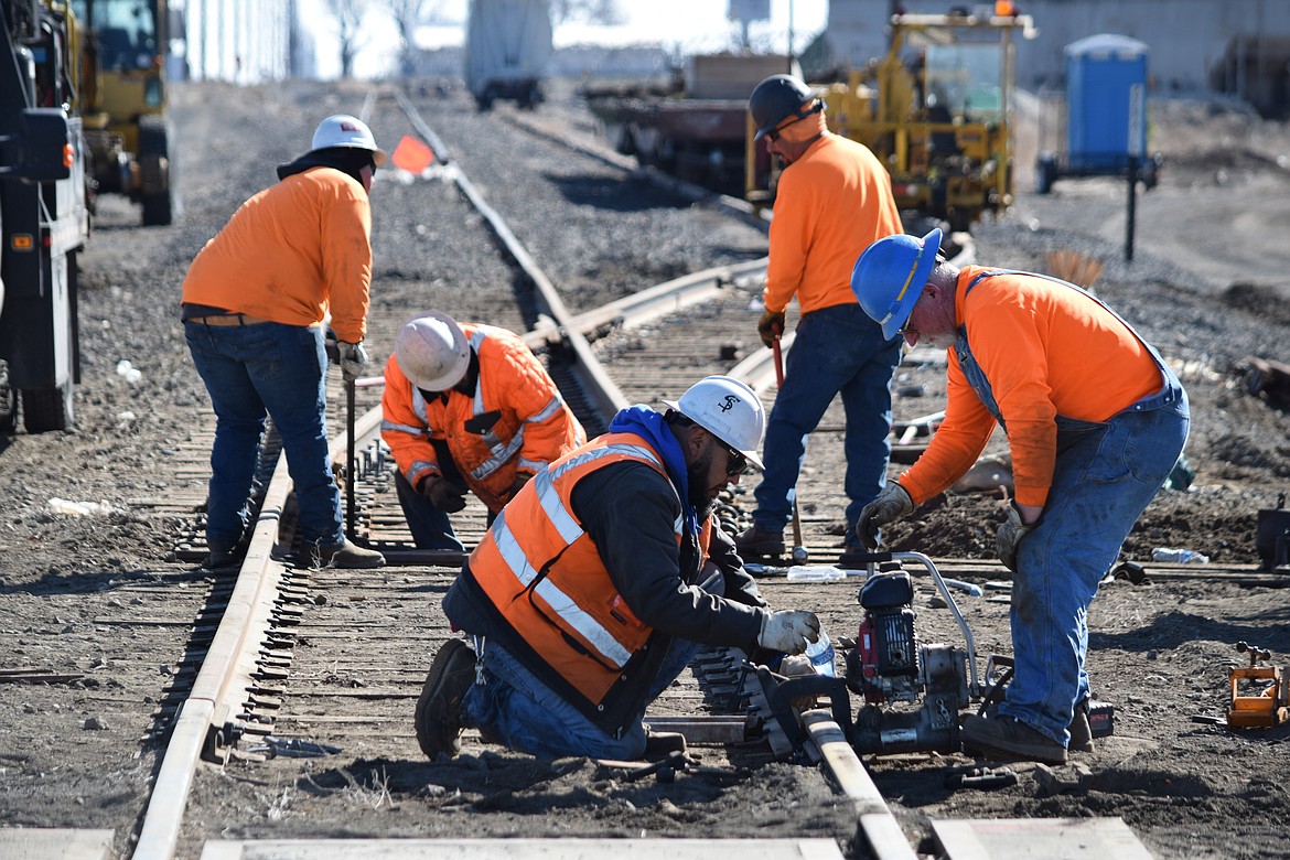 Workers with the Columbia Basin Railroad repair train tracks near the intersection of Wheeler Road and Road N Northeast Tuesday morning.