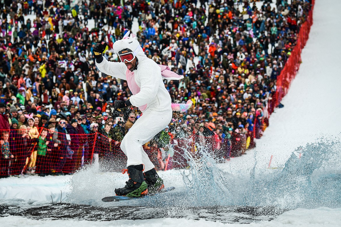 A competitor successfully carves across the water on a snowboard at Whitefish Mountain Resort's pond skim on Saturday, April 8. (Casey Kreider/Daily Inter Lake)