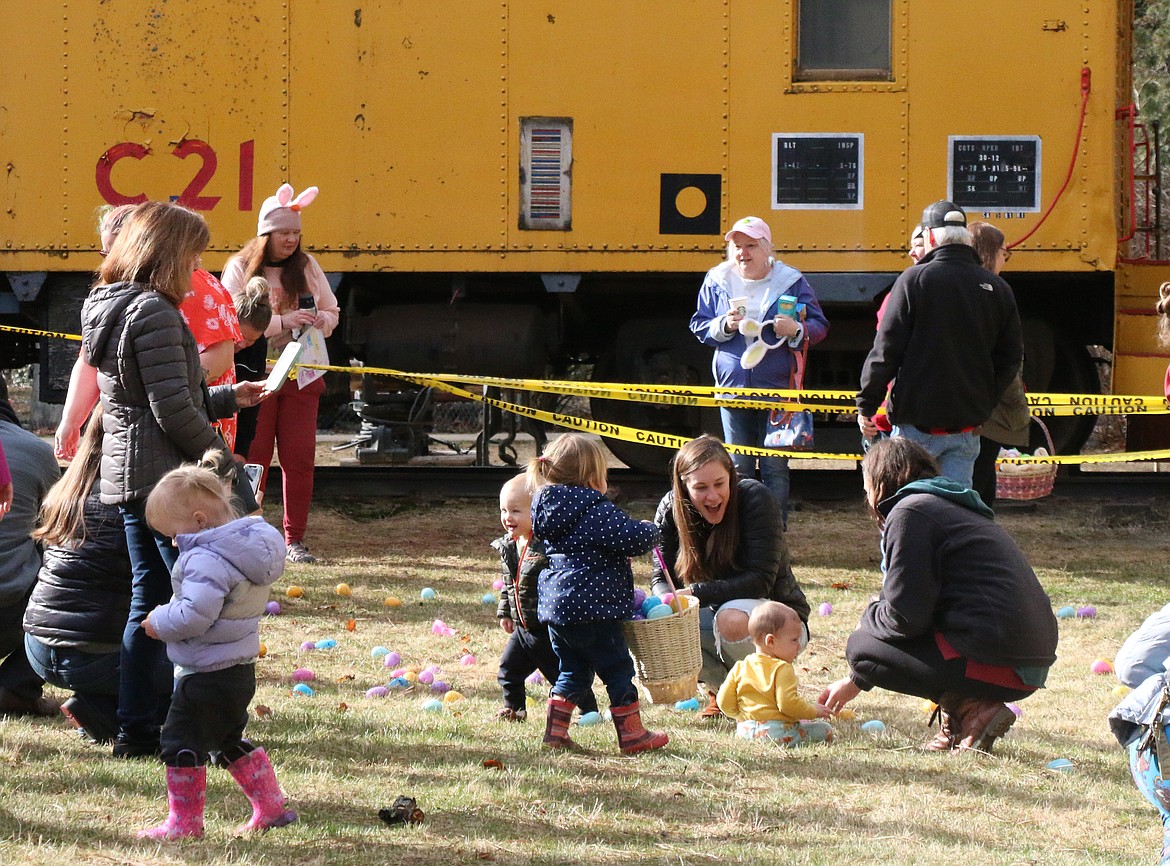 Families have fun peeking inside to see what is inside a plastic Easter egg during the Sandpoint Lions annual Easter egg hunt at Lakeview Park on Saturday.