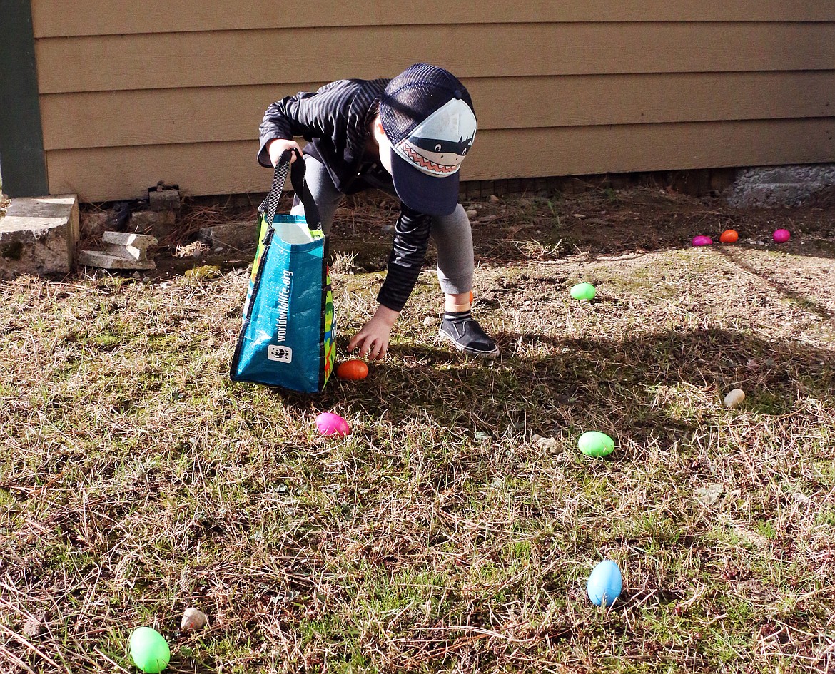Nico Smith reaches to pick up a candy-filled Easter egg at the Sandpoint Lions annual Easter egg hunt at Lakeview Park on Saturday.