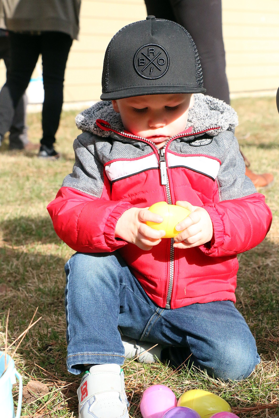 Connor Narwold peeks inside to see what is inside a plastic Easter egg during the Sandpoint Lions annual Easter egg hunt at Lakeview Park on Saturday.