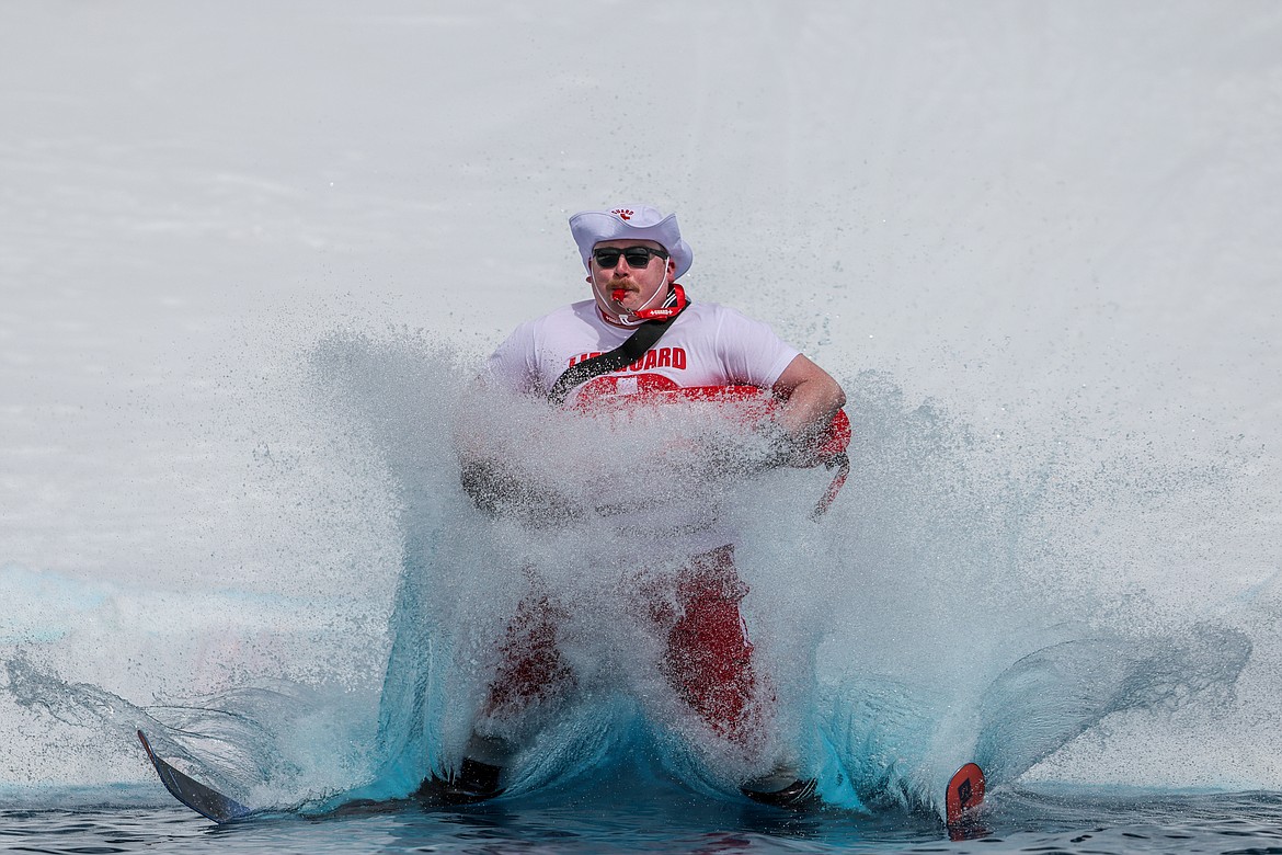 A competitor dressed as a lifeguard takes a nose dive in the Whitefish Mountain Resort Pond Skim on Saturday. (JP Edge photo)